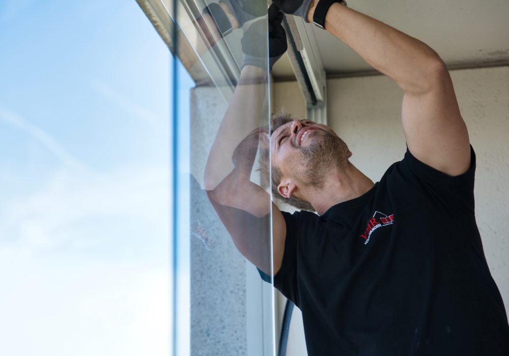 VMR-Vouwwanden-2 Detailshot van man die met twee handen balkonbeglazing aan het monteren is