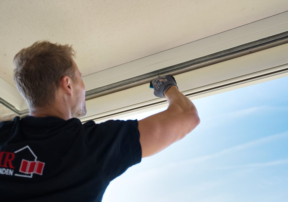 VMR-Vouwwanden-3 Detailshot van man die met gereedschap de rails monteert van de balkonbeglazing