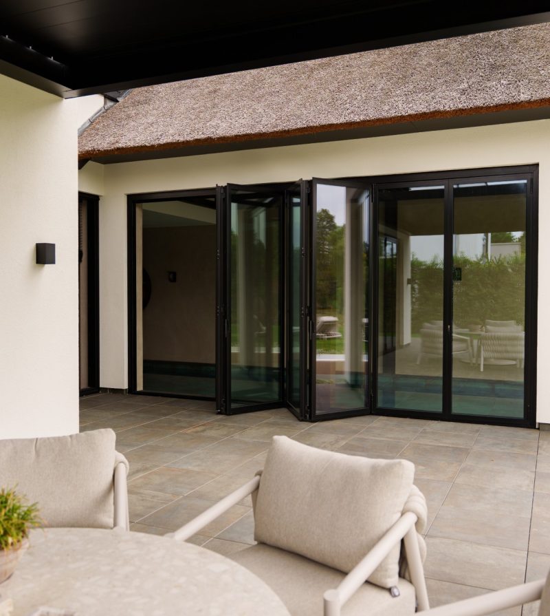 Luxe villa waarvan de vouwwanden halfgeopend zijn waardoor je van zwembad naar het terras kan lopen
