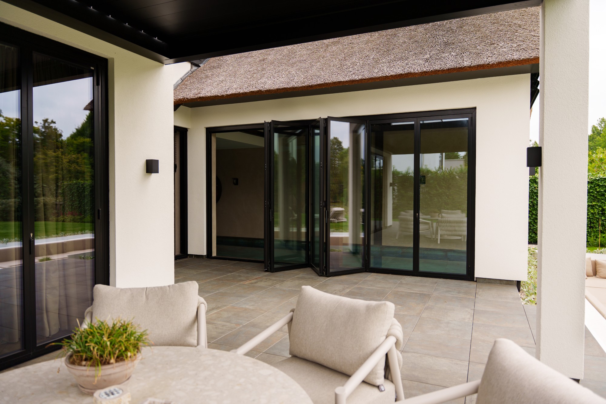 VMR-Vouwwanden-tuin-aanbouw 14 Luxe villa waarvan de vouwwanden halfgeopend zijn waardoor je van zwembad naar het terras kan lopen