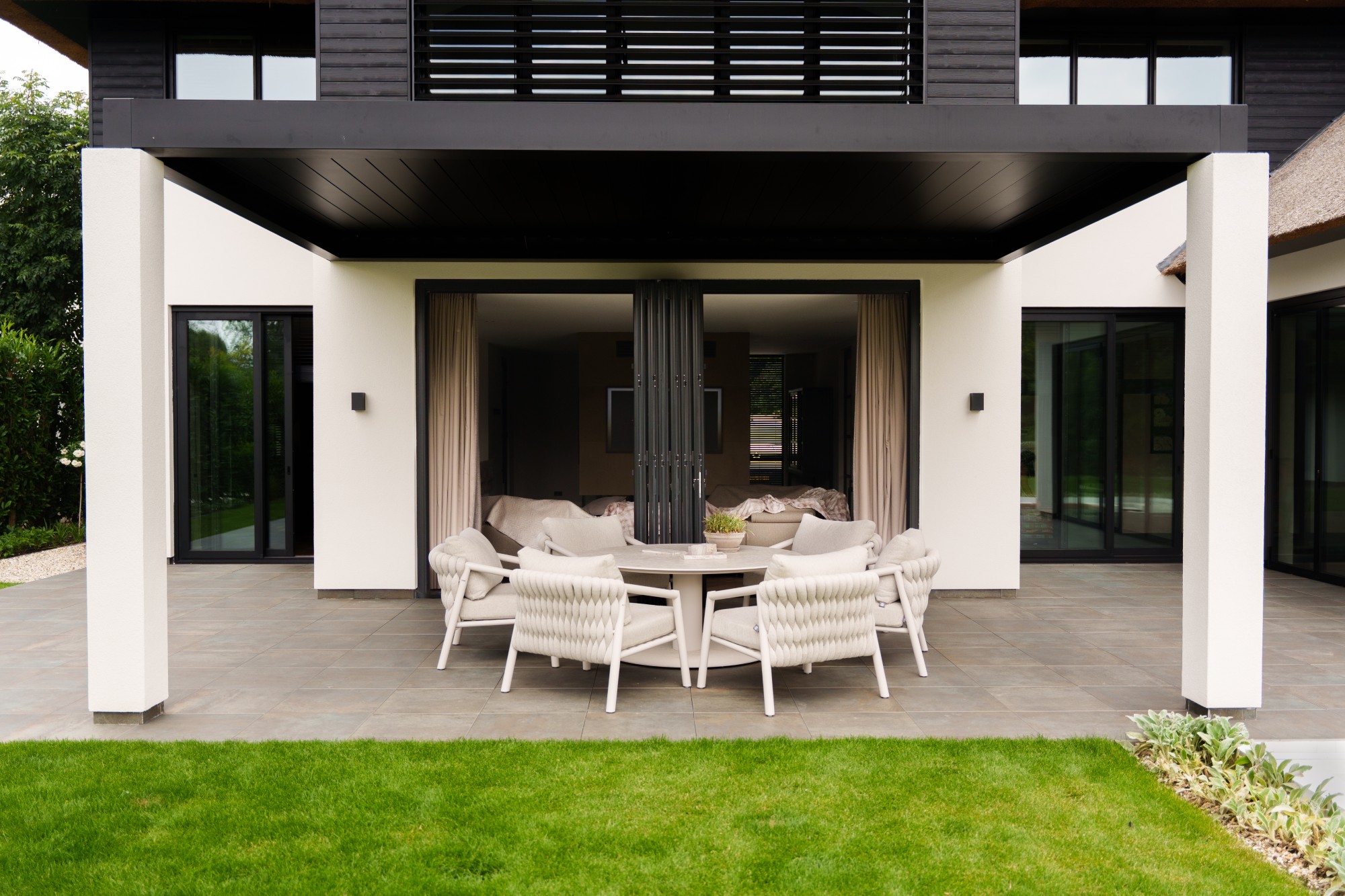 VMR-Vouwwanden-tuin-aanbouw 7 Sfeerbeeld van de geopende vouwwand bij de eethoek in de luxe villa