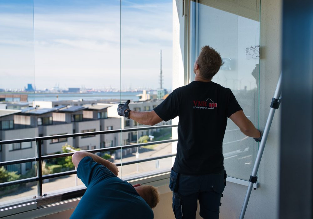 VMR-vouwwanden-5 Beeld van twee mannen die balkonbeglazing aan het monteren zijn