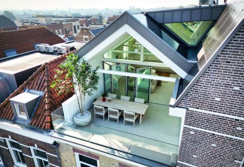 Geopende glazen vouwwand in een appartement met panoramisch uitzicht over de stad